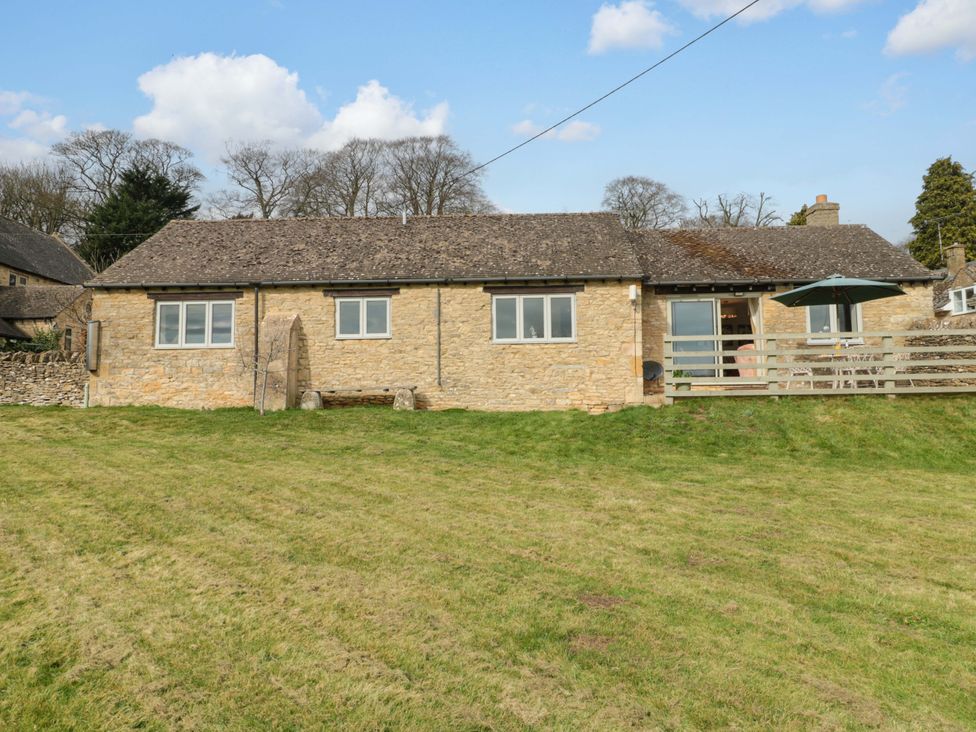 A house with a grassy area and an umbrella at Daisy Bank in Maugersbury near Stow-On-The-Wold