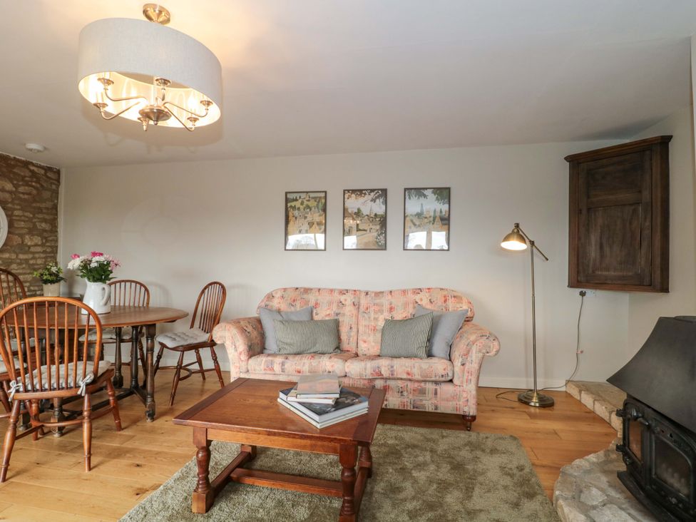 A living room with a sofa and dining table at Daisy Bank Maugersbury near Stow-On-The-Wold