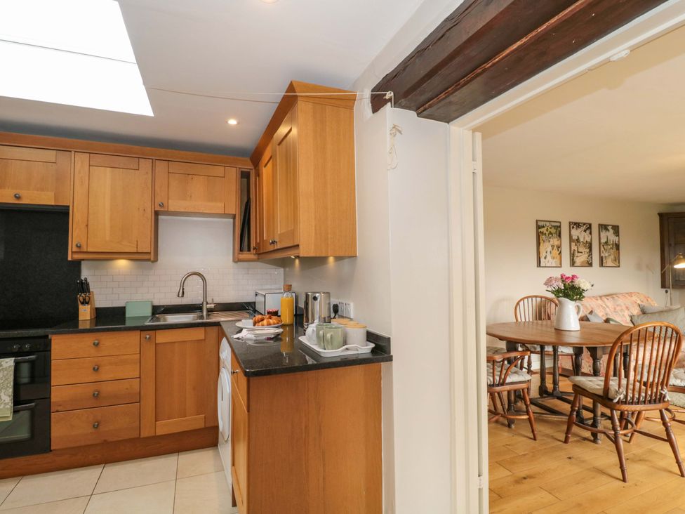 A kitchen with cabinets, sink, and dining area at Daisy Bank in Maugersbury near Stow-On-The-Wold
