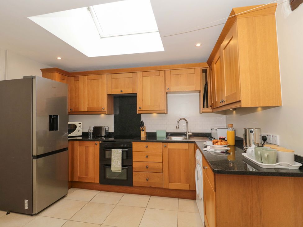 A kitchen with wood cabinets and appliances at Daisy Bank Maugersbury near Stow-On-The-Wold