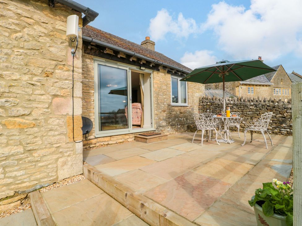 An outdoor area with a table and chairs at Daisy Bank in Maugersbury near Stow-On-The-Wold