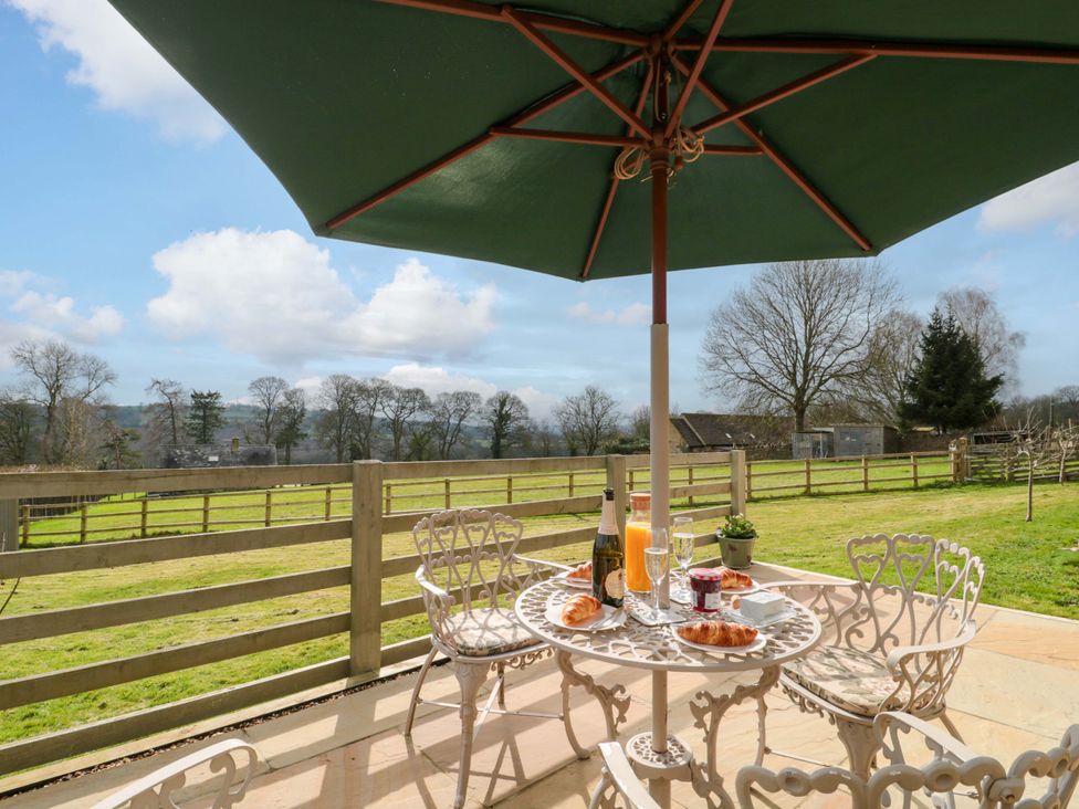 An outdoor patio with a table and food items at Daisy Bank in Maugersbury near Stow-On-The-Wold