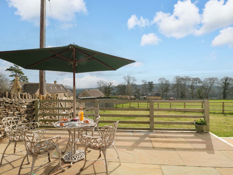 An outdoor patio with a table and chairs at Daisy Bank in Maugersbury near Stow-On-The-Wold