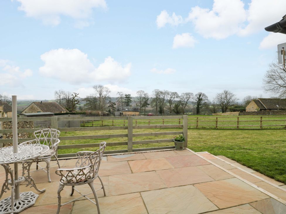 An outdoor area with a table and chairs overlooking a field at Daisy Bank in Maugersbury near Stow-On-The-Wold