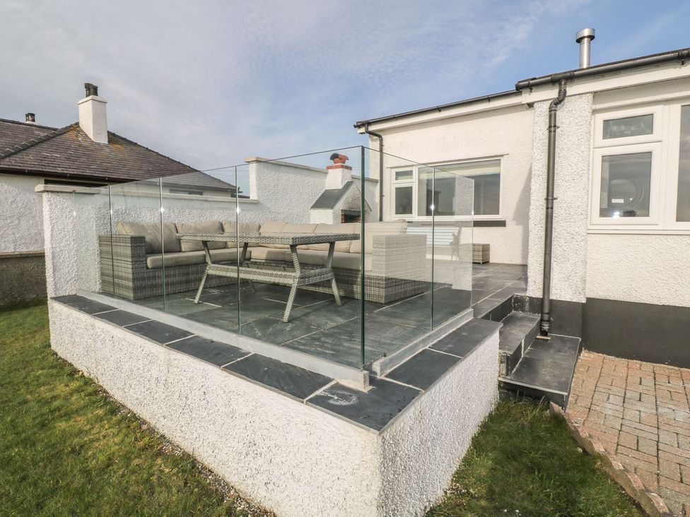 An outdoor seating area with glass railing and table at Dunholme
