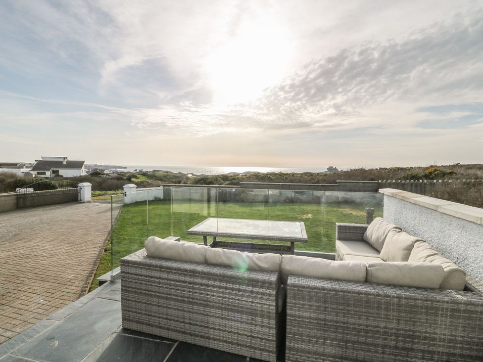 An outdoor seating area with a sofa and table overlooking the ocean at Dunholme