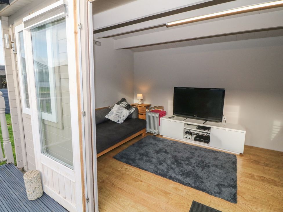 A cozy indoor space with a sofa and television at Dunholme