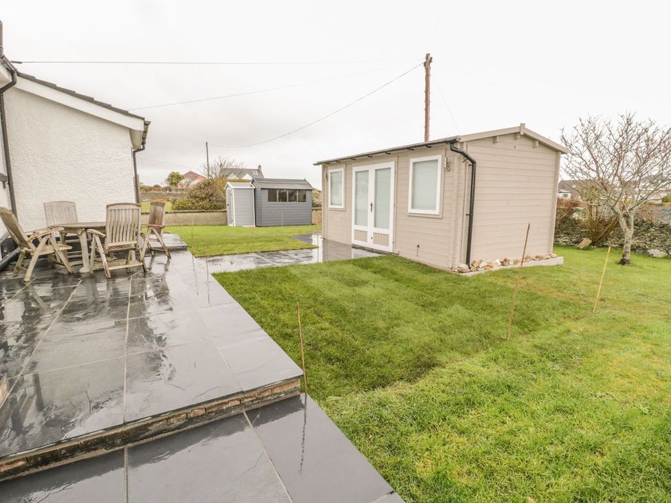 A garden with a patio, table, chairs and shed at Dunholme