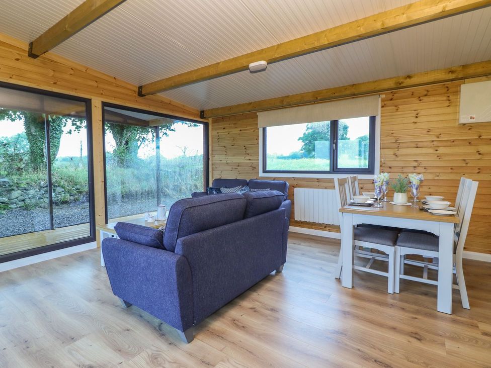 A living room with a sofa and dining table at Killinure Cottage in Glasson, County Westmeath