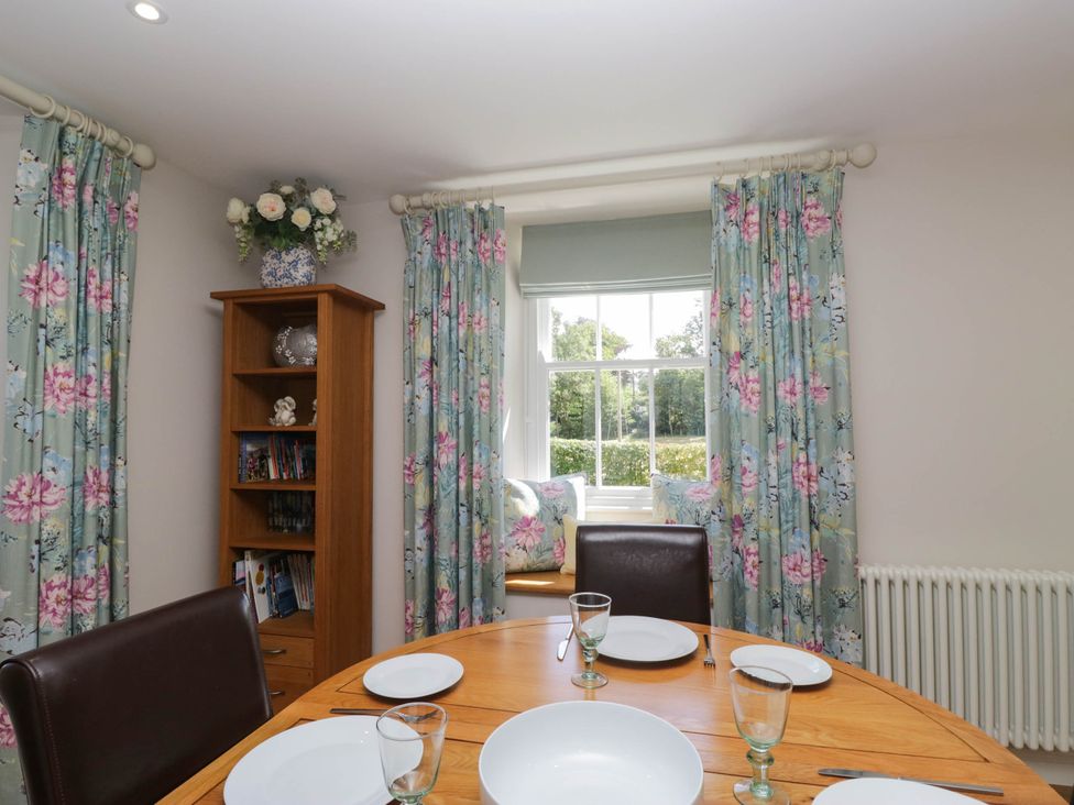 A dining room with a table set for meals at Cragg Cottage in Coniston