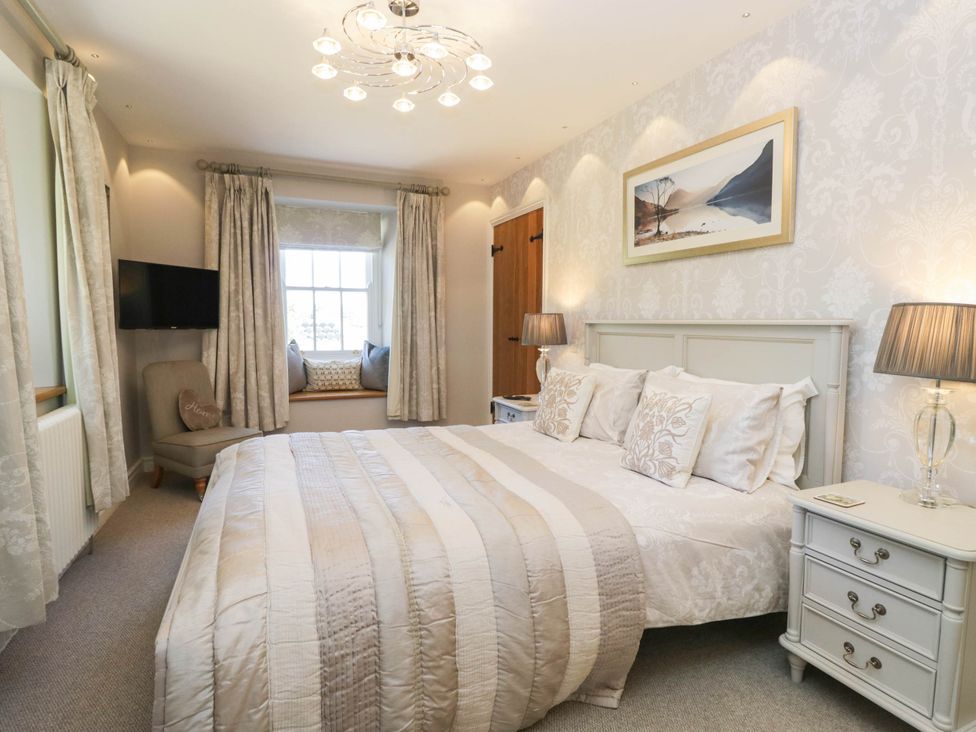 A bedroom with a bed and television at Cragg Cottage in Coniston