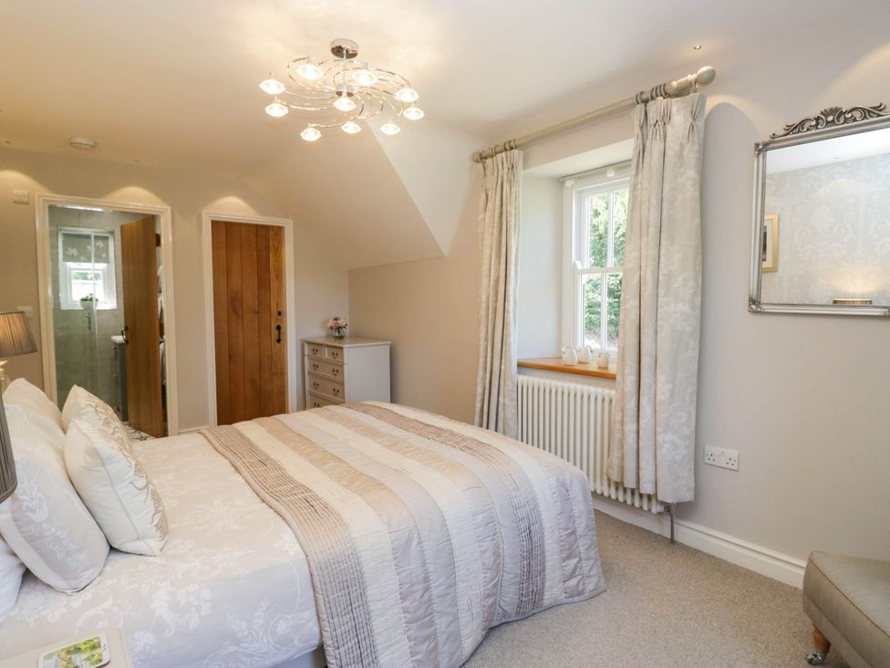 A bedroom with a bed and dresser at Cragg Cottage in Coniston