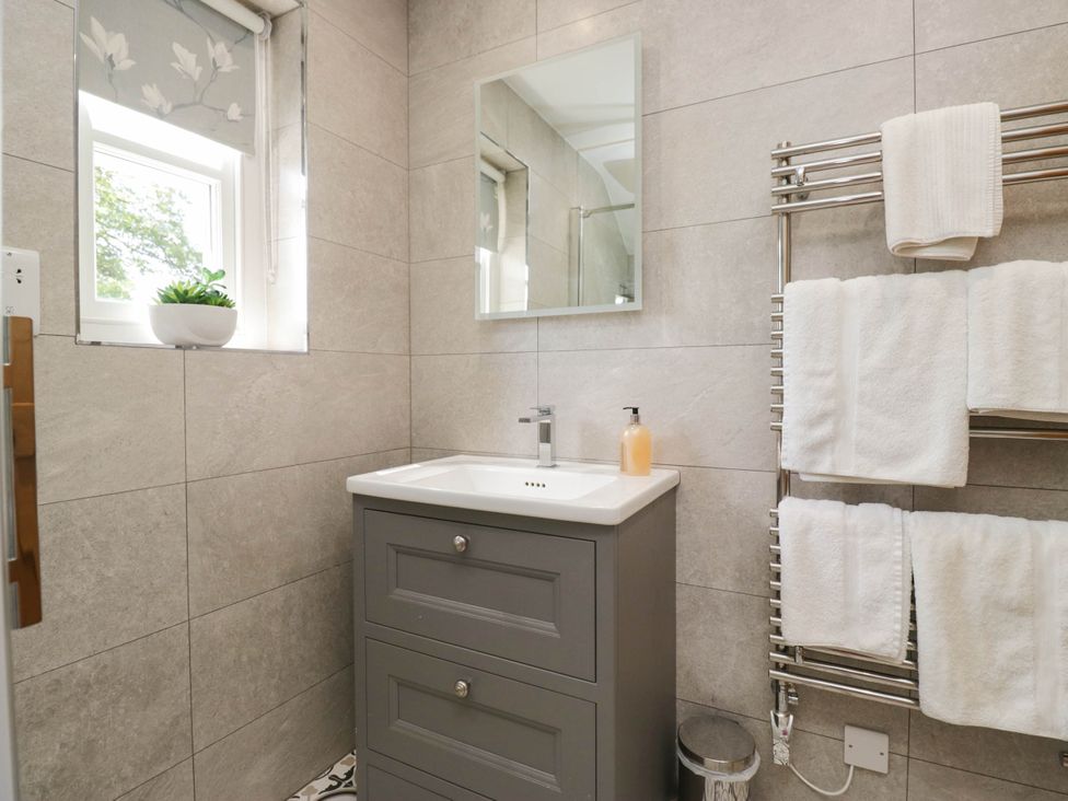 A bathroom with a sink and mirror at Cragg Cottage in Coniston