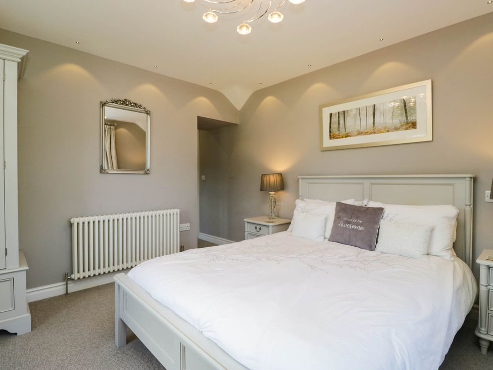 A bedroom with a bed and a lamp at Cragg Cottage in Coniston