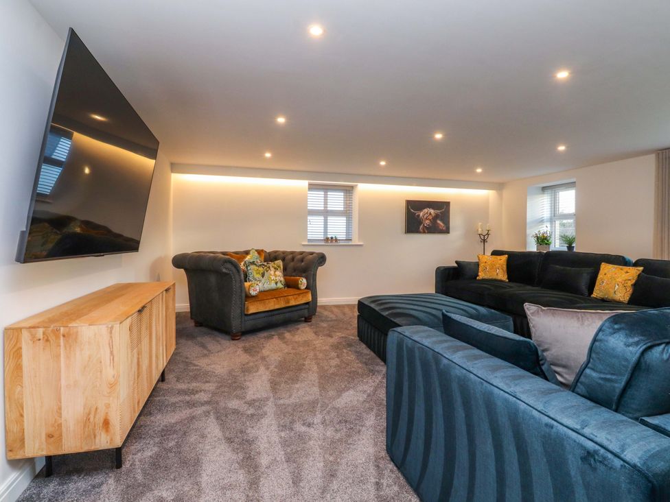 A living room with a television and comfortable seating at The Barn in Skipton