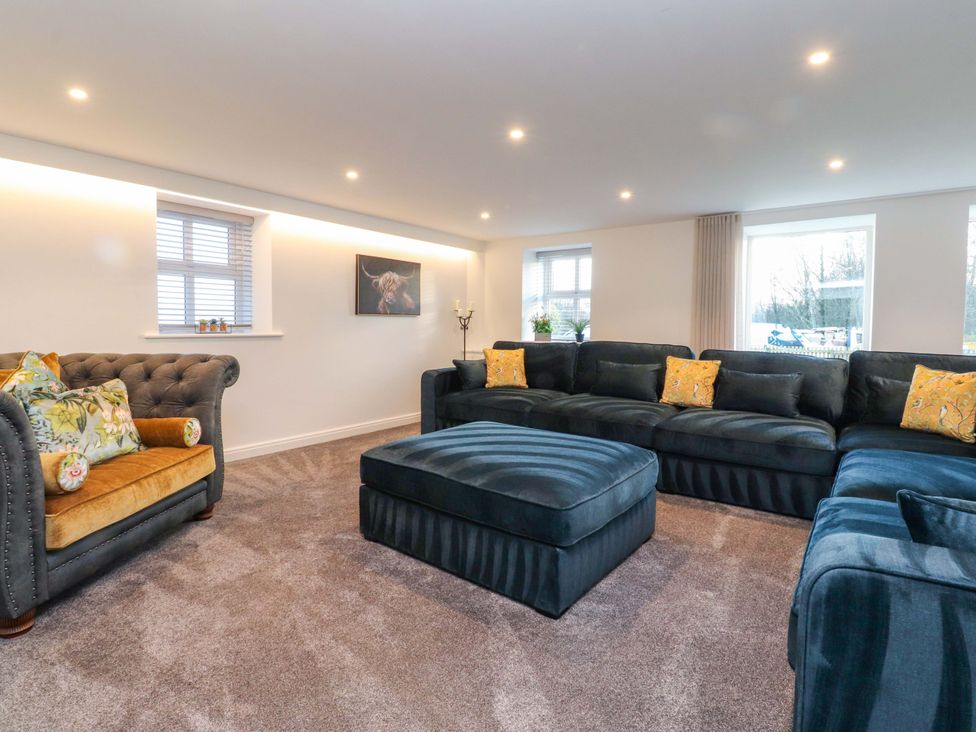 A living room with a sofa and armchair at The Barn in Skipton