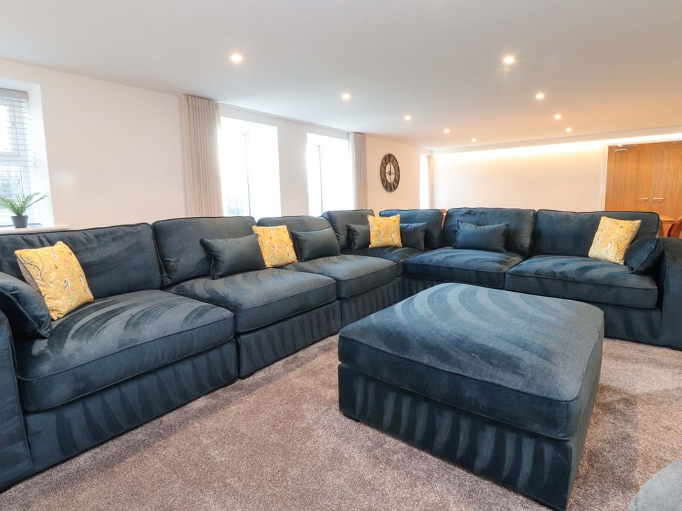 A living room with a sofa and ottoman at The Barn in Skipton