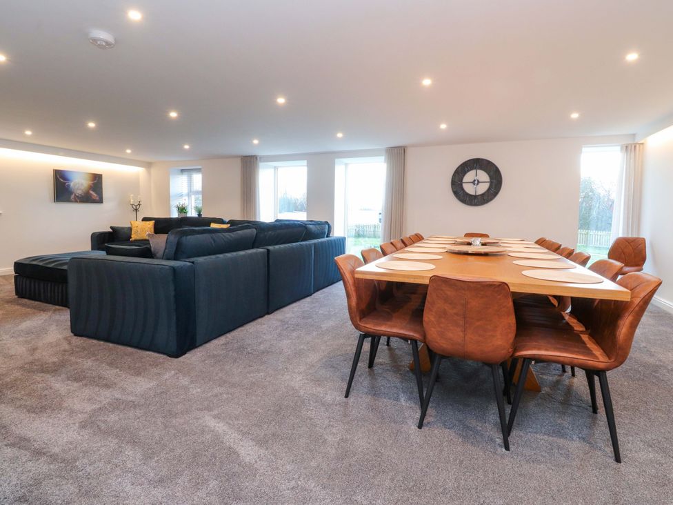 A living room with a sofa and dining area at The Barn in Skipton