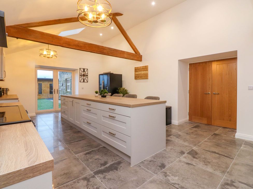 A kitchen with an island and cabinets at The Barn in Skipton