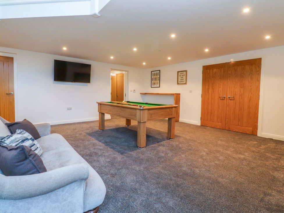 A snug with a pool table and sofa at The Barn in Skipton