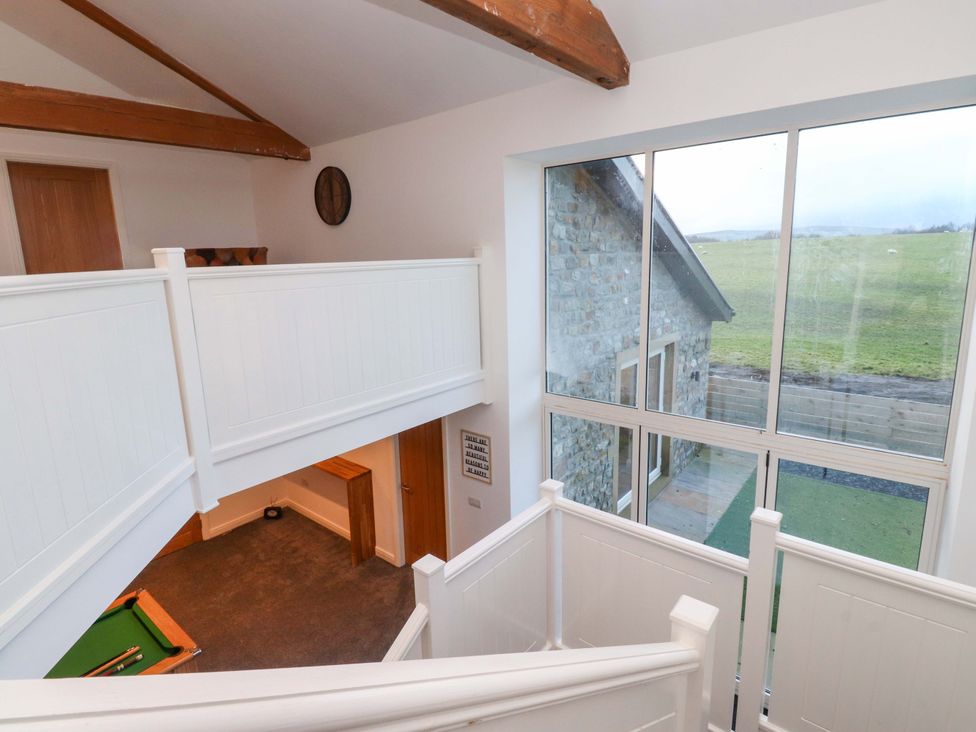 A landing area with stairs and windows at The Barn in Skipton