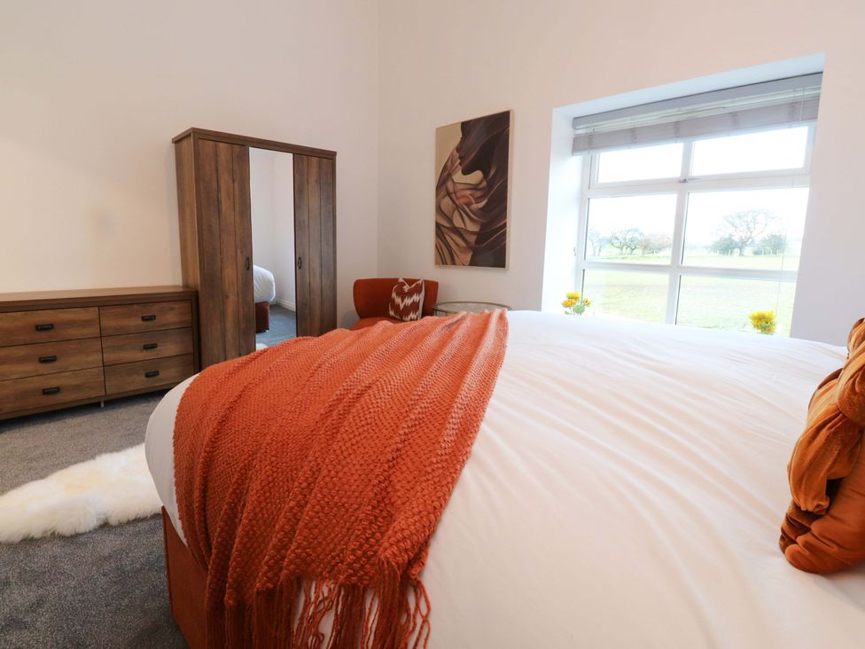 A bedroom with a bed and wardrobe at The Barn in Skipton