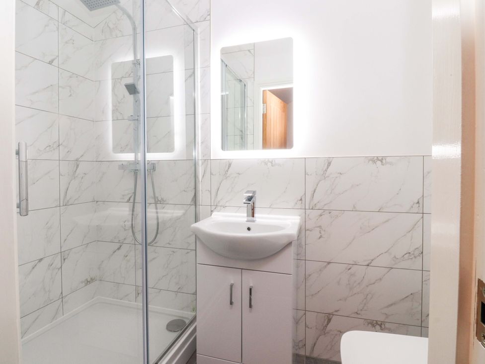 A bathroom with a shower, sink, and toilet at The Barn in Skipton