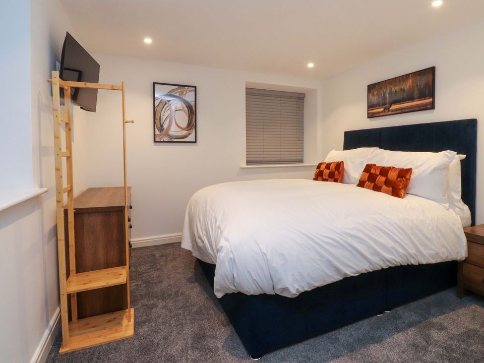 A bedroom with a bed and television at The Barn in Skipton