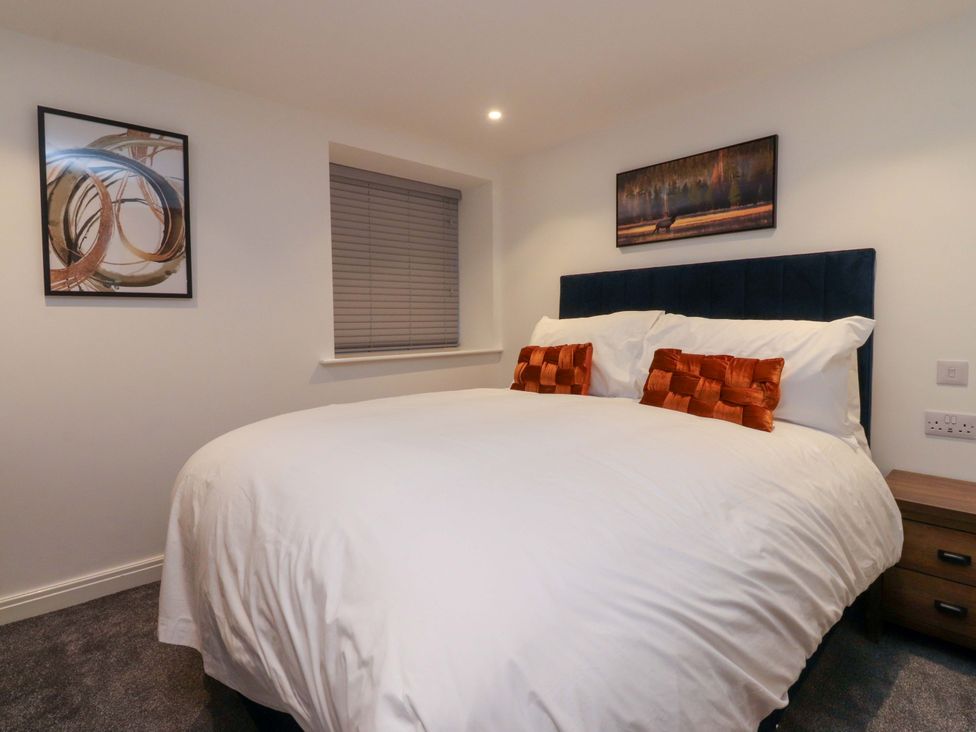 A bedroom with a large bed and nightstand at The Barn in Skipton