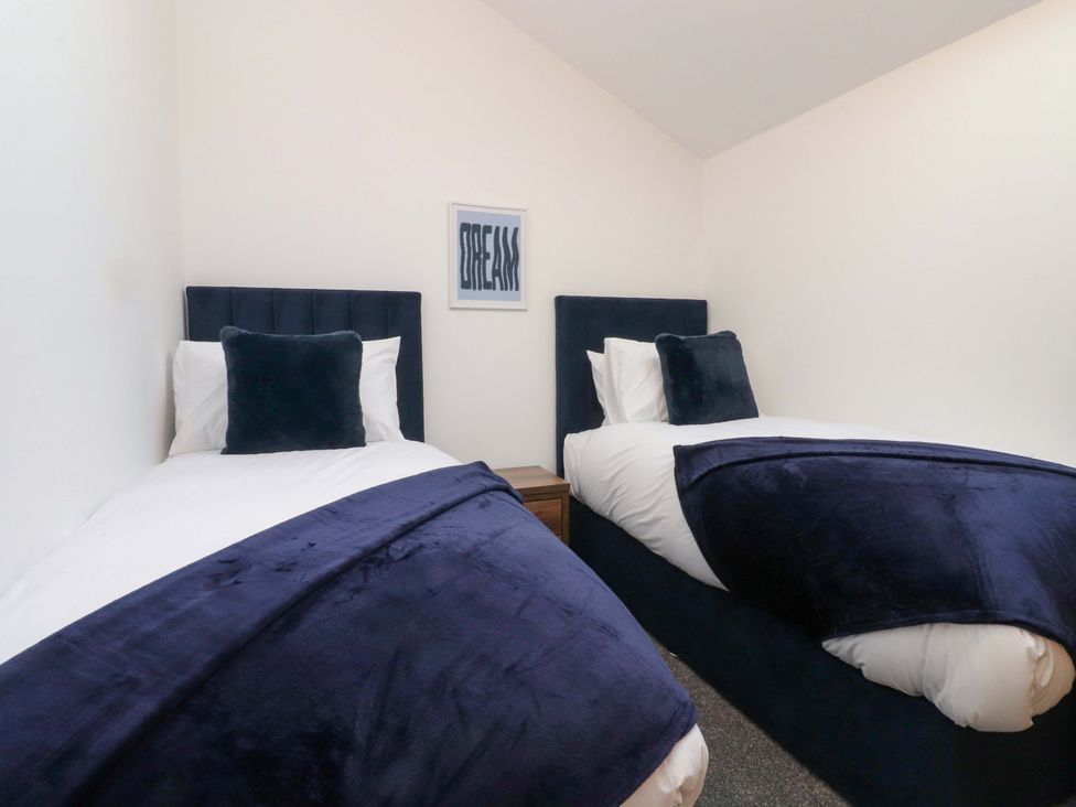 A bedroom with two beds and wall art at The Barn in Skipton