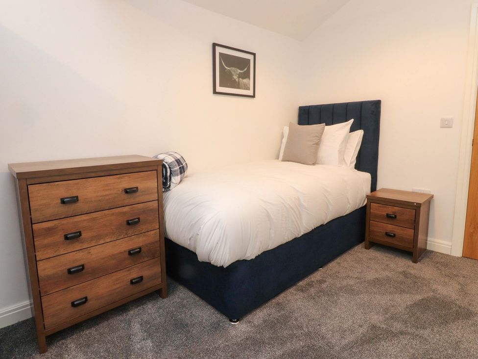 A bedroom with a single bed and furniture at The Barn in Skipton