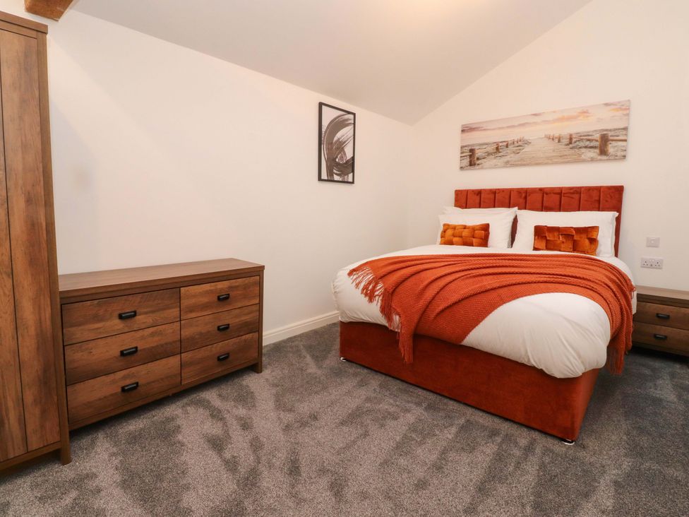 A bedroom with a bed and dresser at The Barn in Skipton