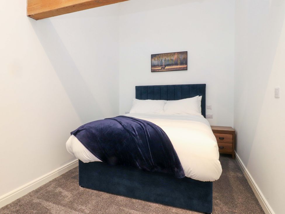 A bedroom with a bed and bedside cabinet at The Barn in Skipton