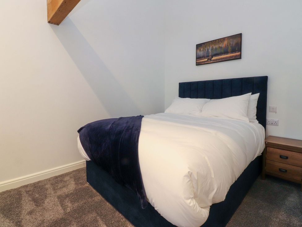 A bedroom with a bed and bedside table at The Barn in Skipton