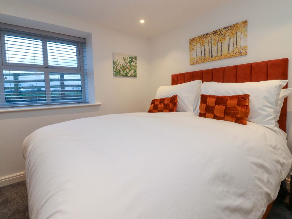 A bedroom with a bed and window at The Barn in Skipton