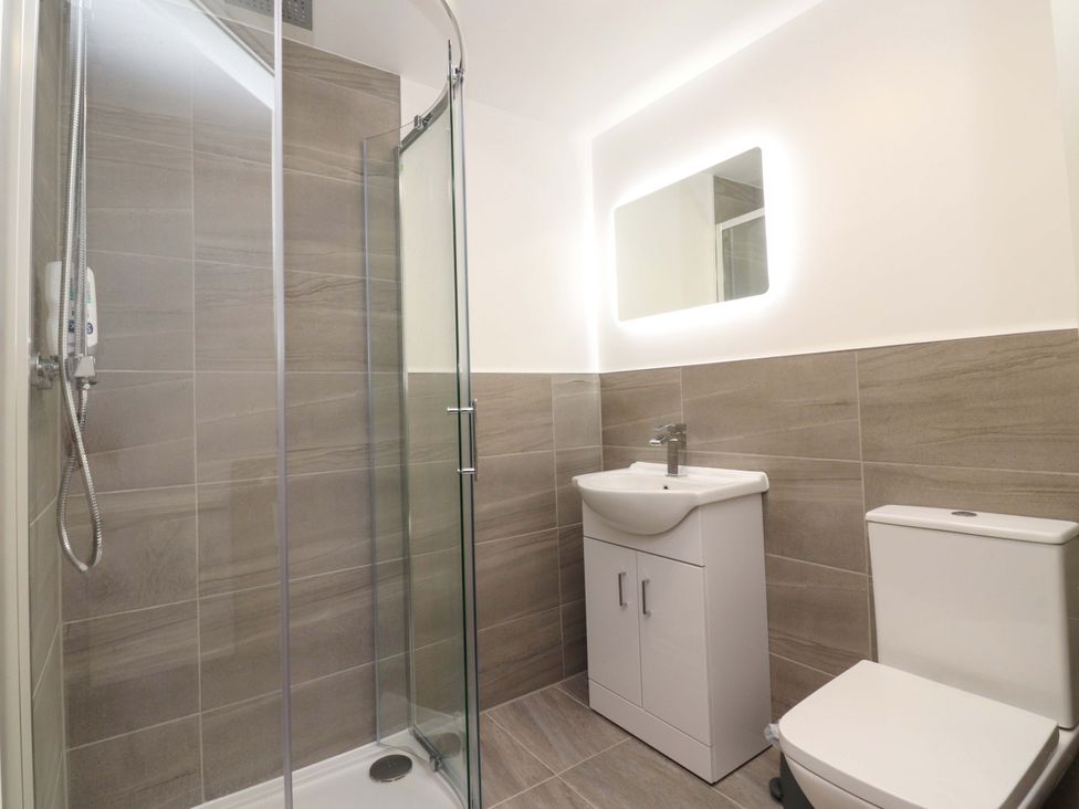 A bathroom with a shower, sink, and toilet at The Barn in Skipton