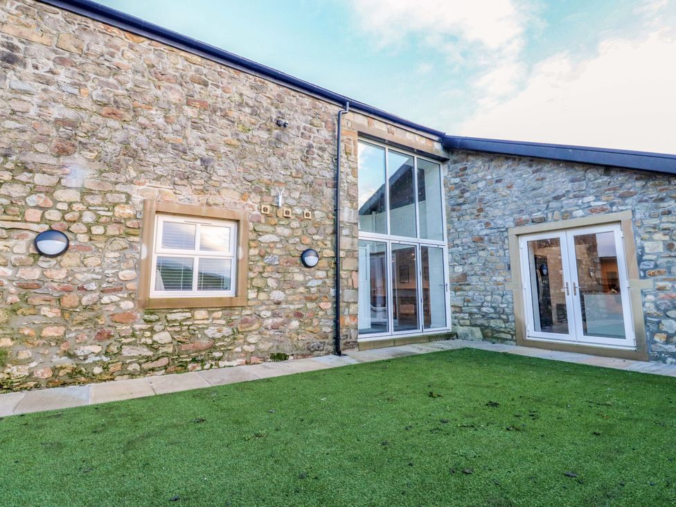 An outdoor area with grass and stone walls at The Barn in Skipton