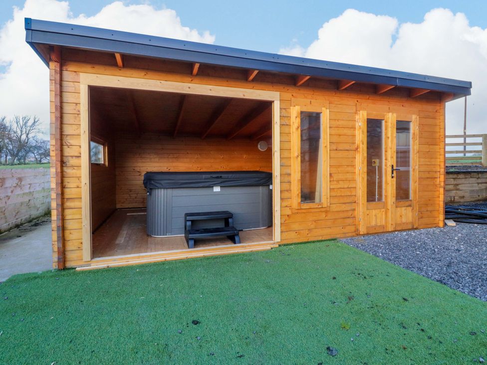 An outdoor hot tub with steps in a wooden structure at The Barn in Skipton