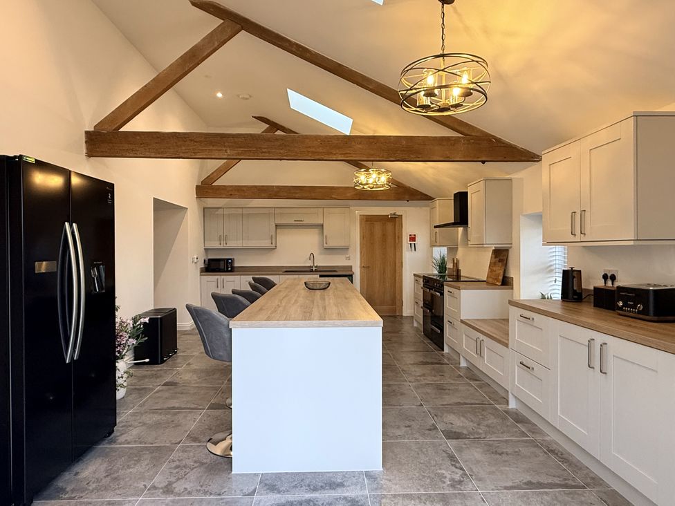 A kitchen with a refrigerator, oven, and island at The Barn in Wigglesworth near Settle