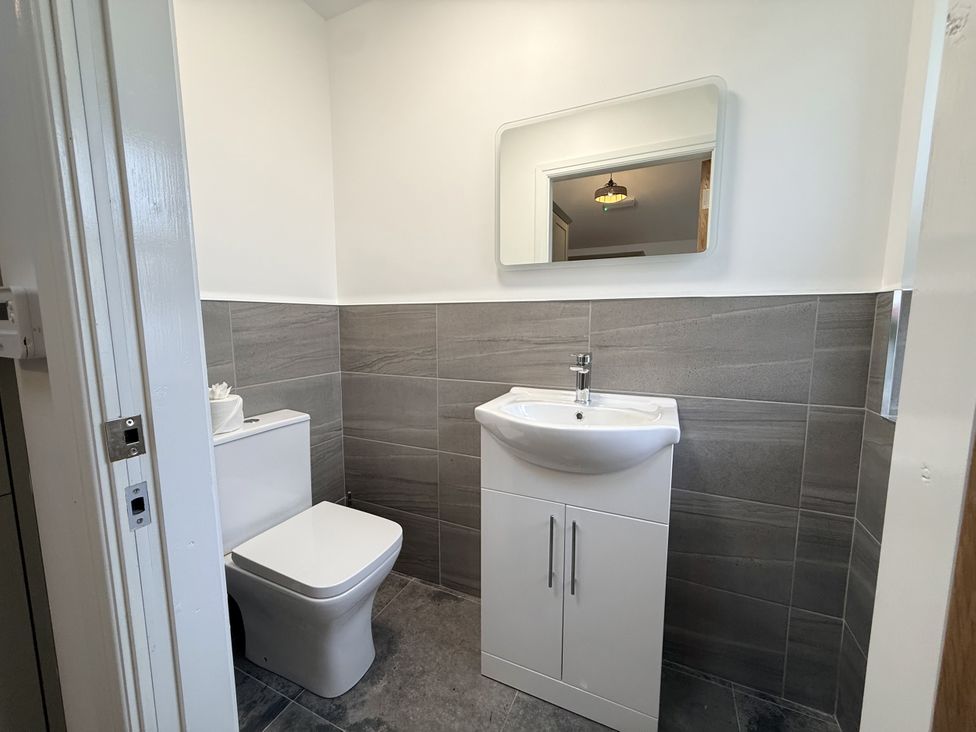 A bathroom with a sink, toilet, and mirror at The Barn in Wigglesworth near Settle