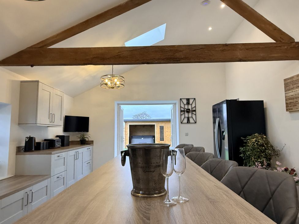 A kitchen with a dining table and refrigerator at The Barn in Wigglesworth near Settle