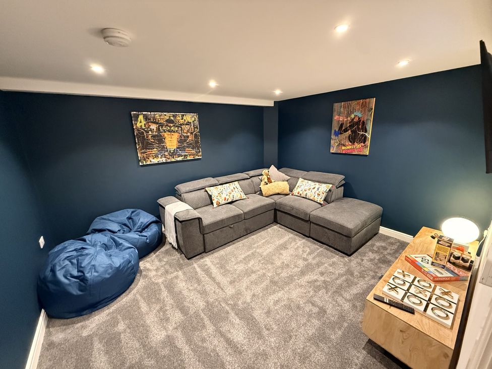 A snug with a sofa, bean bags, and wall art at The Barn in Wigglesworth near Settle