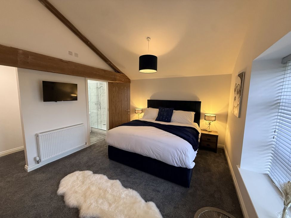 A bedroom with a bed and television at The Barn in Wigglesworth near Settle