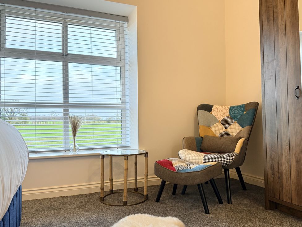 A bedroom with a window, a chair, and a table at The Barn in Wigglesworth near Settle
