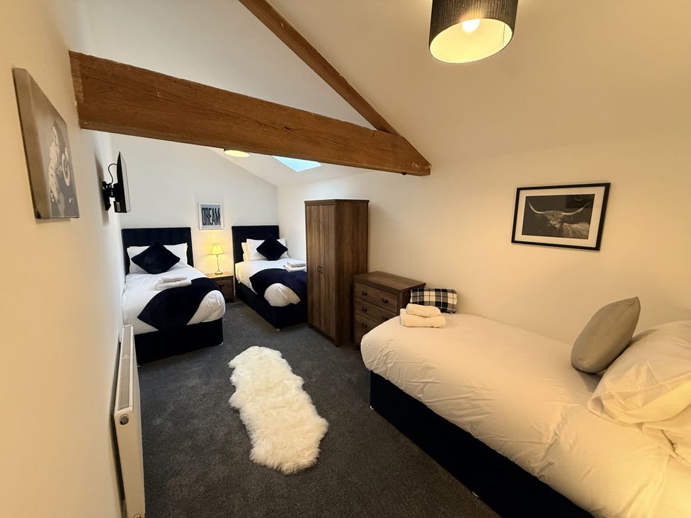 A bedroom with two beds and furniture at The Barn in Wigglesworth near Settle