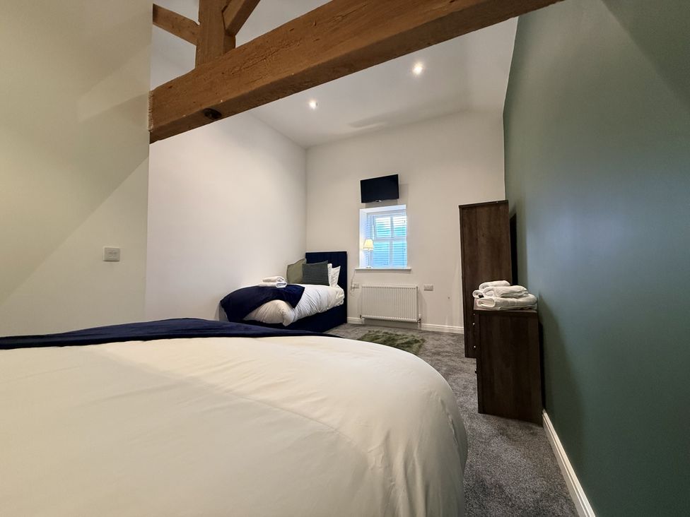A bedroom with a double bed and a single bed at The Barn in Wigglesworth near Settle