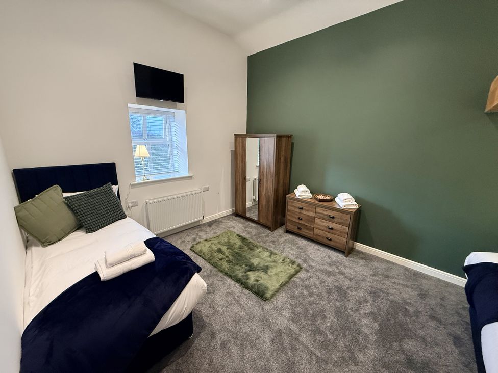 A bedroom with a bed and dresser at The Barn in Wigglesworth near Settle
