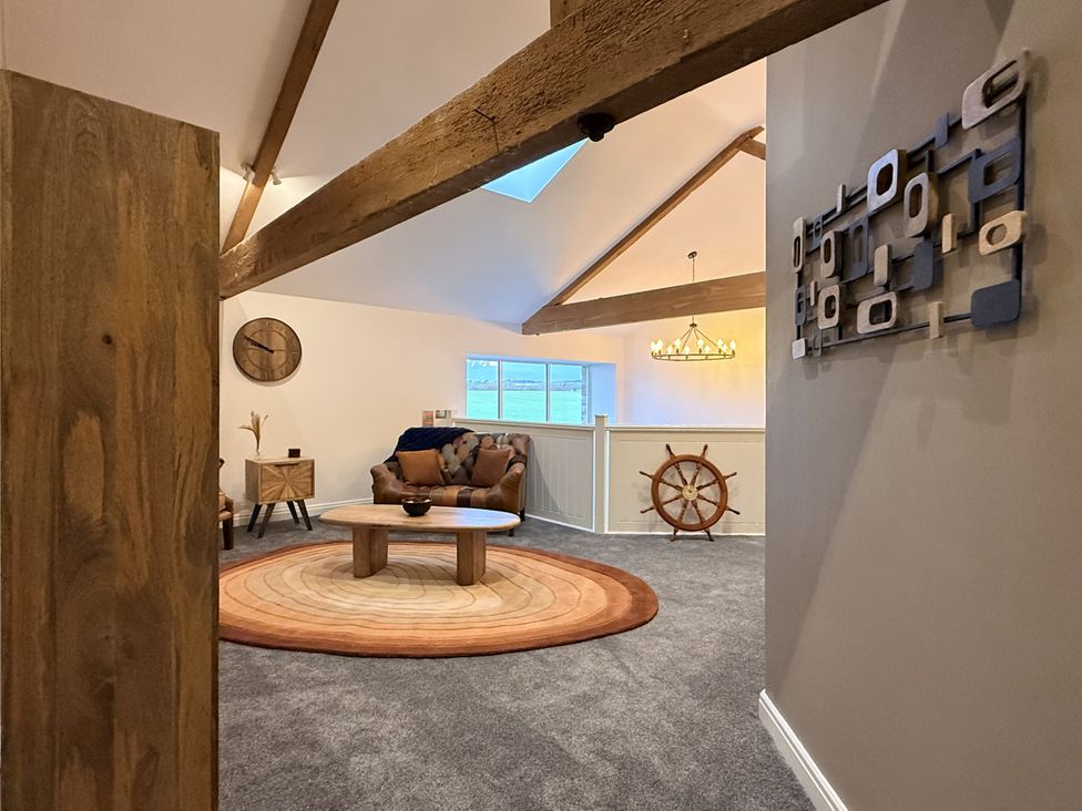 A living room with a sofa and a round table at The Barn in Wigglesworth near Settle