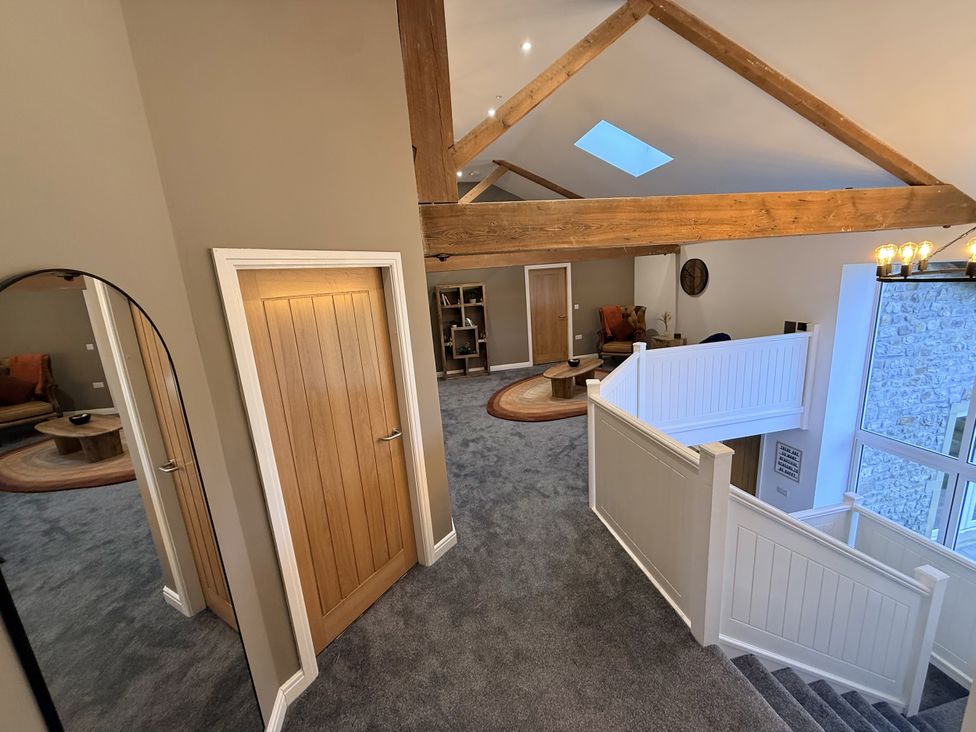 A hallway with a staircase and wooden beams at The Barn in Wigglesworth near Settle