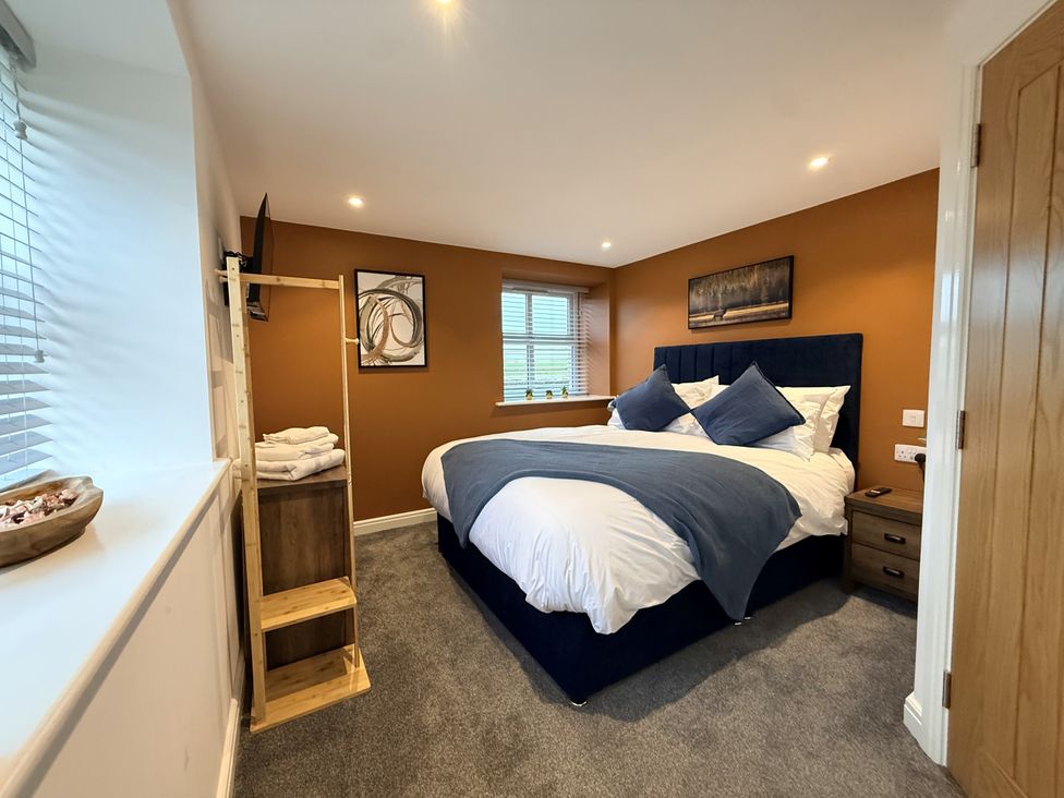 A bedroom with a bed and nightstand at The Barn Wigglesworth near Settle